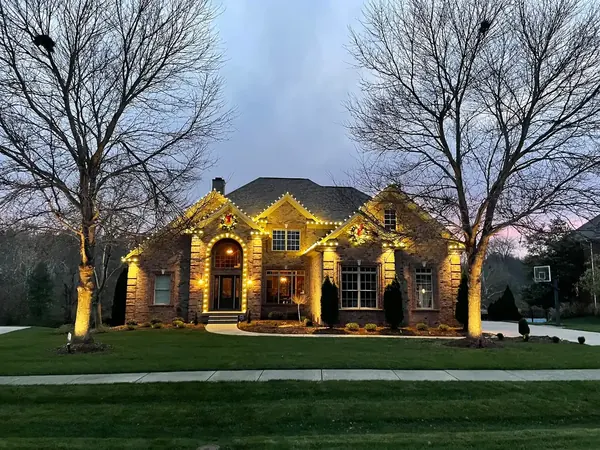 Warm white Christmas lights installed along a residential roofline