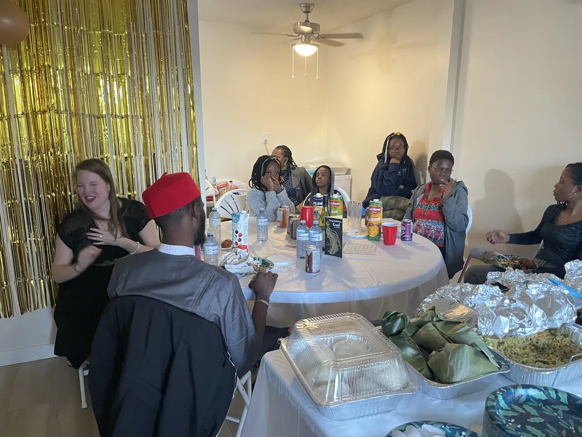 Round table and white folding chairs at an indoor family gathering