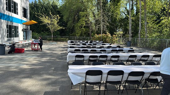 Clean white round tables and chairs set up at a corporate event with ambient indoor lighting