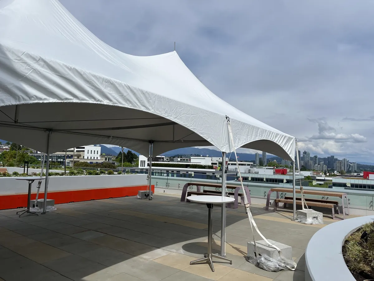 A frame tent installed on a rooftop patio with the downtown Vancouver skyline and North Shore mountains behind